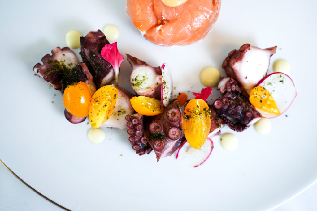 “Polpo e salmone gourmet con verdure colorate e fiori eduli – catering Rama Eventi”